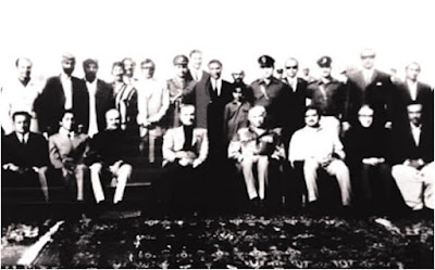 Ghulam Siddique Qadri with Emperor Pahlavi and Zulfikar Ali Bhutto – 20th Century Diplomatic Gathering Historic black-and-white photograph featuring Ghulam Siddique Qadri seated with Mohammad Reza Pahlavi, the Emperor of Iran, and Zulfikar Ali Bhutto in a formal outdoor setting.