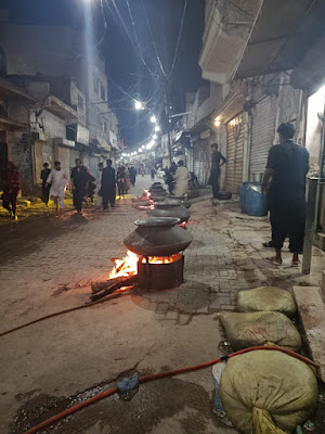 Haleem Niaz Preparation on the Streets of Rohri for Muharram Community members preparing Haleem as a Niaz offering on the streets of Rohri during Muharram, symbolizing unity and devotion at Karbala