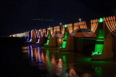 Close-up image of Sukkur Barrage's arches festooned with cascading white LED strings and green pillar illuminations, celebrating Azadi Mubarak with a blend of modern lights and historical architecture in Sindh, Pakistan.