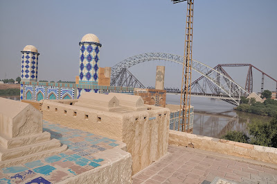 Tiled Domes of Sateen Jo Aastan: Views of Indus River Bridges in Rohri, Pakistan Blue-tiled domes and stone graves at Sateen Jo Aastan overlooking Lansdowne and Ayub Bridges on Indus River, Rohri, Sindh, Pakistan