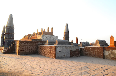 Tiled Pillars and Arches of Sateen Jo Aastan: River Overlook in Rohri, Pakistan Side view of blue-tiled arches and patterned pillars at Sateen Jo Aastan overlooking Indus River and bridge, Rohri, Sindh, Pakistan