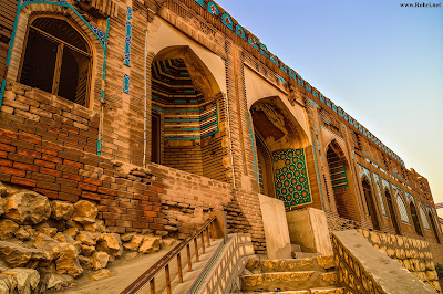 Sunset View of Sateen Jo Aastan: Historic Tomb of the Seven Sisters in Rohri, Pakistan Ancient brick facade of Sateen Jo Aastan tomb with blue tile arches and stone steps overlooking the Indus River at sunset in Rohri, Sindh, Pakistan