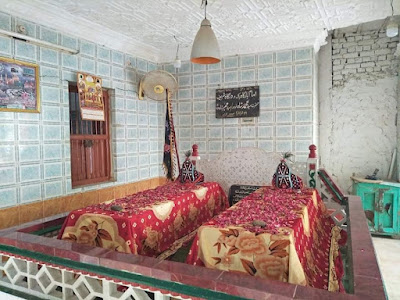 Grave of Syed Muhammad Shah Al-Musavi at shrine in Sukkur, surrounded by religious flags and spiritual inscriptions, reflecting centuries of devotion and Mirki Sadat heritage