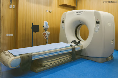 CT scan room at Sukkur Civil Hospital with Toshiba scanner, wooden walls, and blue flooring.