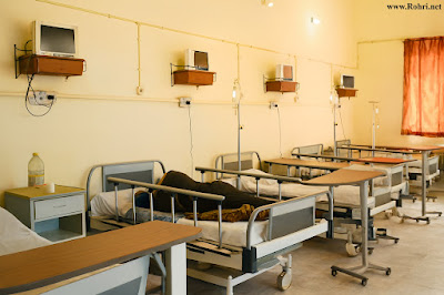 Hospital ward at Sukkur Civil Hospital with patient beds, IV stands, monitors, and medical supplies.
