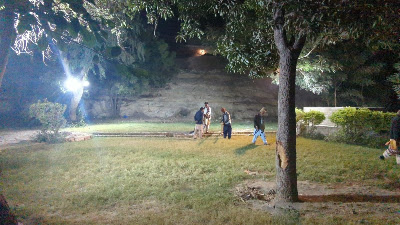 Nighttime Social Scene in Tekchand Bolchand Park Sukkur Group of people gathering on the grassy area at night in Tekchand Bolchand Park Sukkur, with steps and rock wall backdrop, historic site Sindh Pakistan