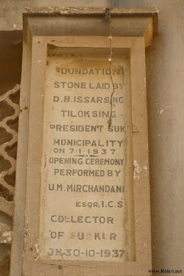 This historic plaque commemorates the laying of the foundation stone by D.B. Issarsing Tiloksing, President of Sukkur Municipality, on January 7, 1937, and the opening ceremony performed by U.M. Mirchandani, Esq., I.C.S., Collector of Sukkur, on October 30, 1937 — a proud civic milestone in Sindh’s pre-independence history. Commemorative plaque marking the 1937 foundation and opening of a municipal building in Sukkur, Sindh.